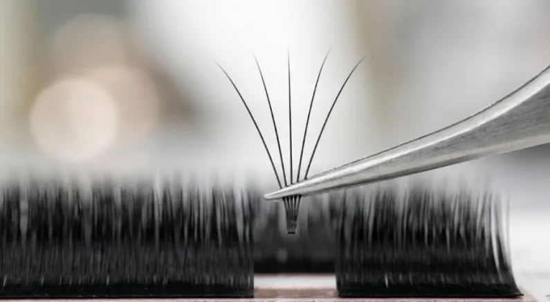 ESSI LASH tweezers pulling a bloomed 5D lash fan.
