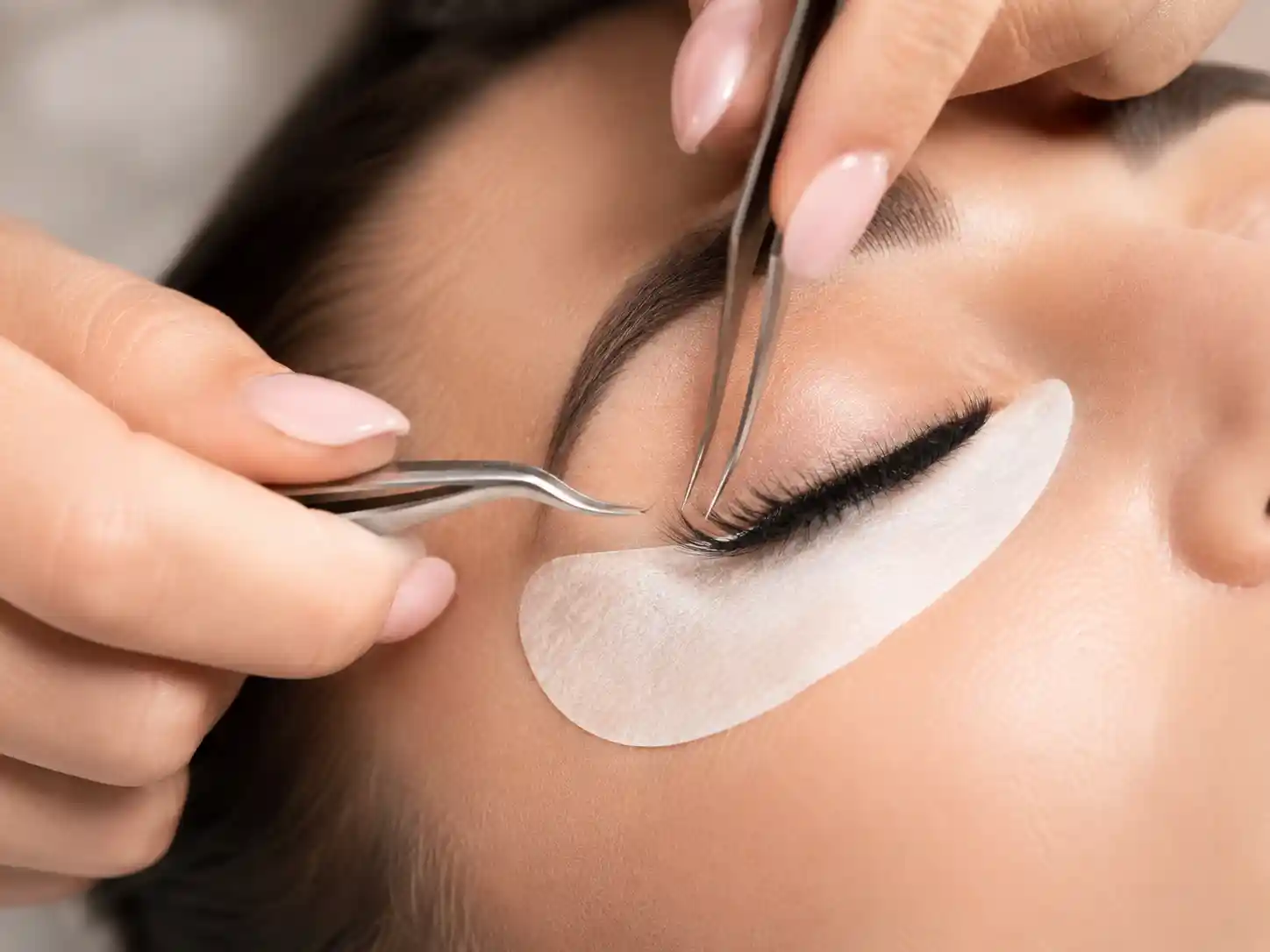 False eyelash trays, tweezers, and eye close-up